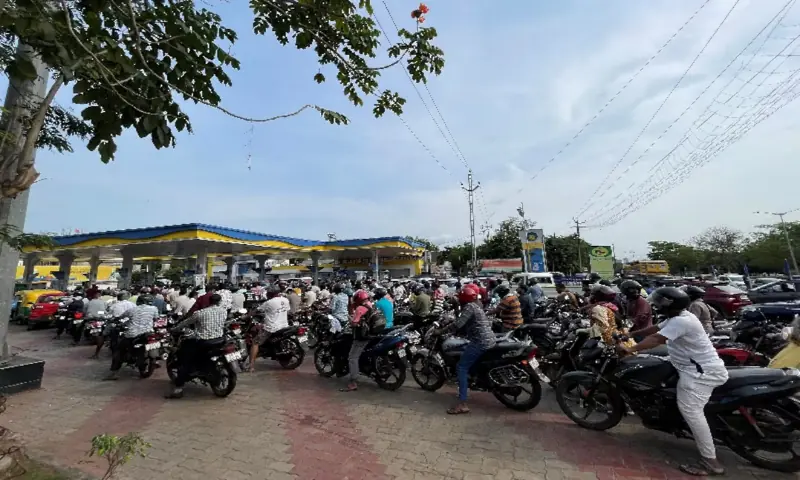 Motorists queue to fill fuel in their vehicles at a fuel station in Bhubaneswar, India. -- Reuters