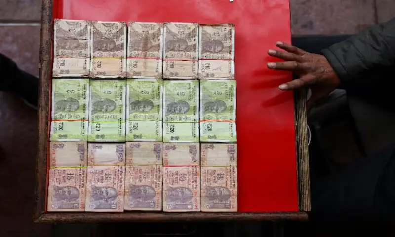 A vendor displays various denominations of Indian currency at a roadside currency exchange stall in the old quarters of Delhi, India. -- Reuters file