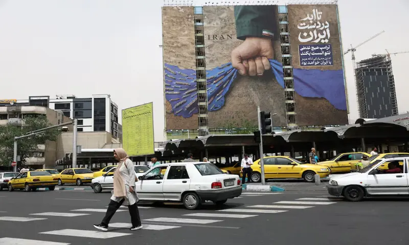 People walk past a billboard with a graphic design about the Strait of Hormuz on a building, in Tehran, Iran, on May 4, 2026. Reuters file