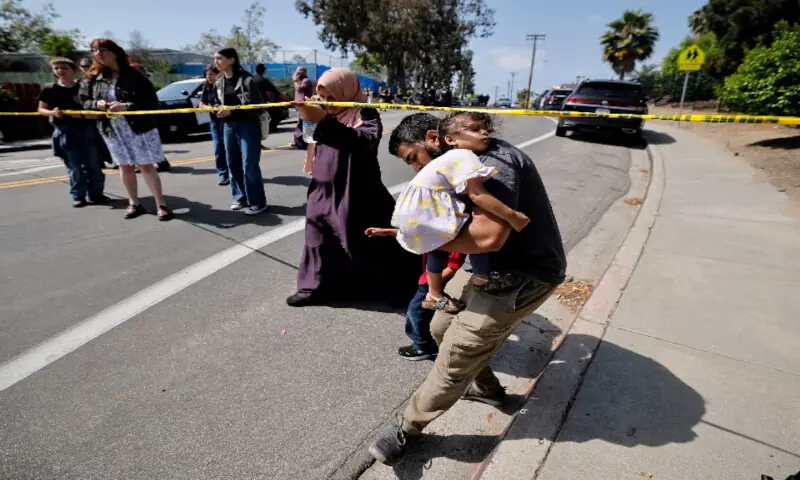 A parent passes under yellow tape cordoning an area at the scene of a shooting at the Islamic Centre in San Diego, California. -- Reuters A parent passes under yellow tape cordoning an area at the scene of a shooting at the Islamic Centre in San Diego, California. -- Reuters