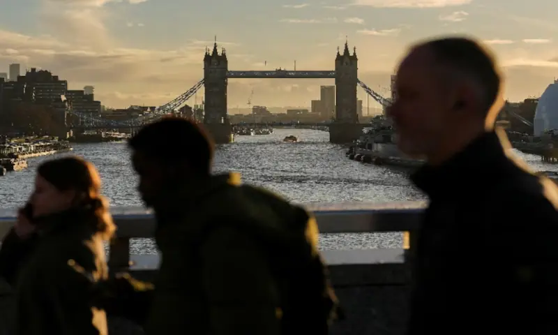 People walk across London Bridge during the morning commute rush, in London, Britain. -- Reuters