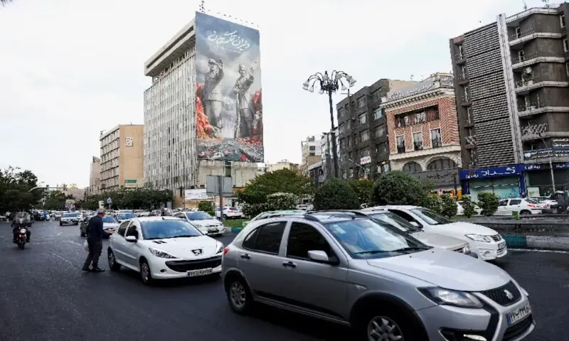 People drive past a billboard about the Strait of Hormuz, in Tehran, Iran, on May 17, 2026. Reuters