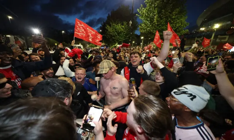 Arsenal fans celebrate outside the Emirates stadium as Arsenal win the Premier League title. -- Reuters