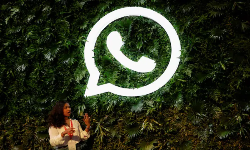 A woman stands next to a logo of messaging application Whatsapp during a Meta conference in Mumbai, India. -- Reuters file