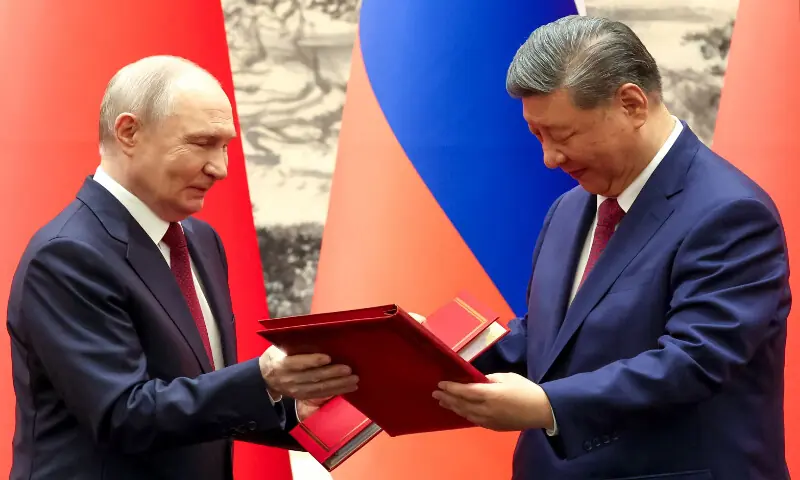 Russia's President Vladimir Putin and China's President Xi Jinping exchange documents during a signing ceremony following their talks in Beijing on May 20, 2026. AFP