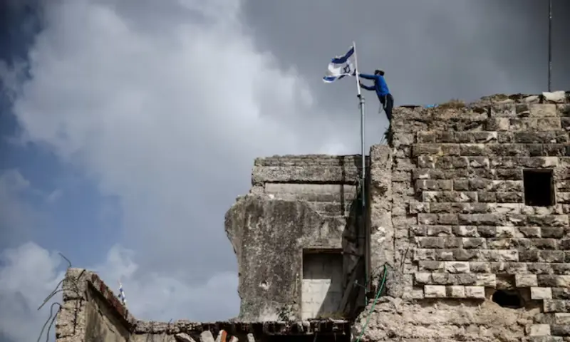 An Israeli settler places an Israeli flag on the day of the re-establishment of the settlement of Sa-Nur, which was evacuated as part of Israel’s 2005 disengagement, in Sa-Nur in the Israeli-occupied West Bank. -- Reuters An Israeli settler places an Israeli flag on the day of the re-establishment of the settlement of Sa-Nur, which was evacuated as part of Israel’s 2005 disengagement, in Sa-Nur in the Israeli-occupied West Bank. -- Reuters