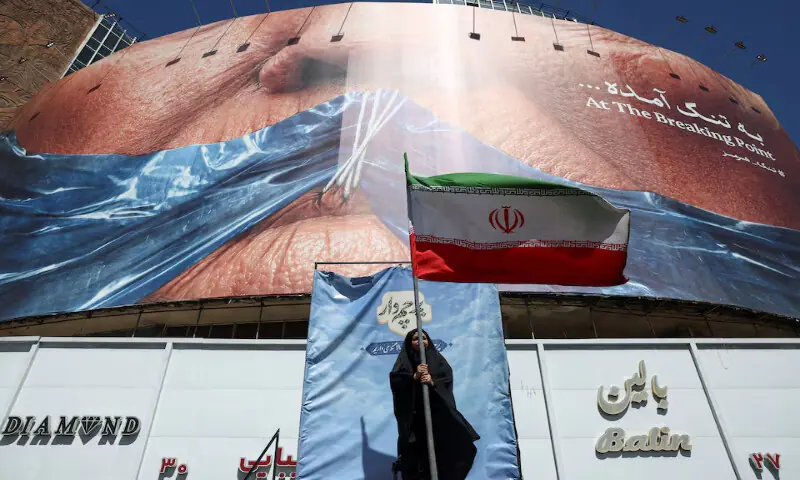 A woman holds an Iranian flag near an anti-US billboard in Tehran, Iran, May, on Monday. -- Reuters A woman holds an Iranian flag near an anti-US billboard in Tehran, Iran, May, on Monday. -- Reuters