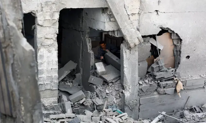 A Palestinian man inspects the site of an Israeli airstrike on a residential building on Tuesday, in Gaza City. -- Reuters