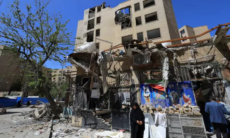 A woman stands next to debris lying in front of a residential building damaged by a strike on March 4, in Tehran, Iran. -- Reuters A woman stands next to debris lying in front of a residential building damaged by a strike on March 4, in Tehran, Iran. -- Reuters