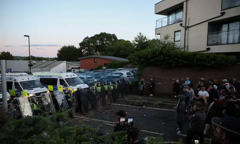 Protesters stand facing police officers during a demonstration following the conviction of Vikrum Digwa for the murder of student Henry Nowak in Southampton, Britain. -- Reuters