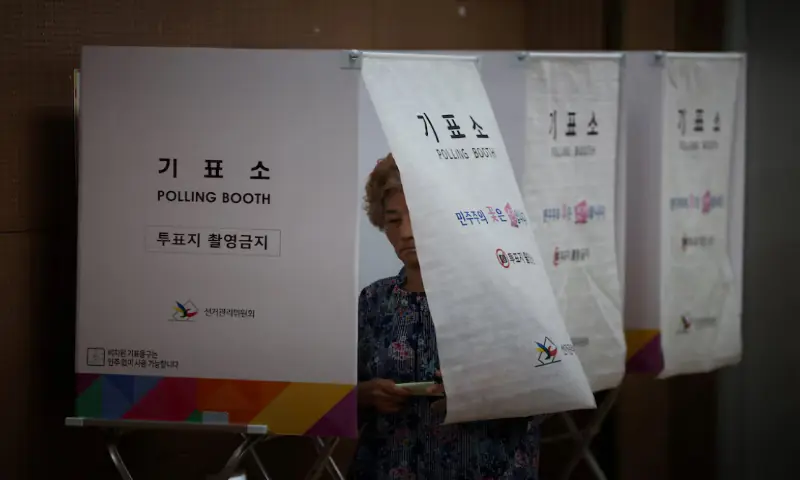 A woman leaves a voting booth during the local elections at a polling station in Seoul, South Korea. -- Reuters