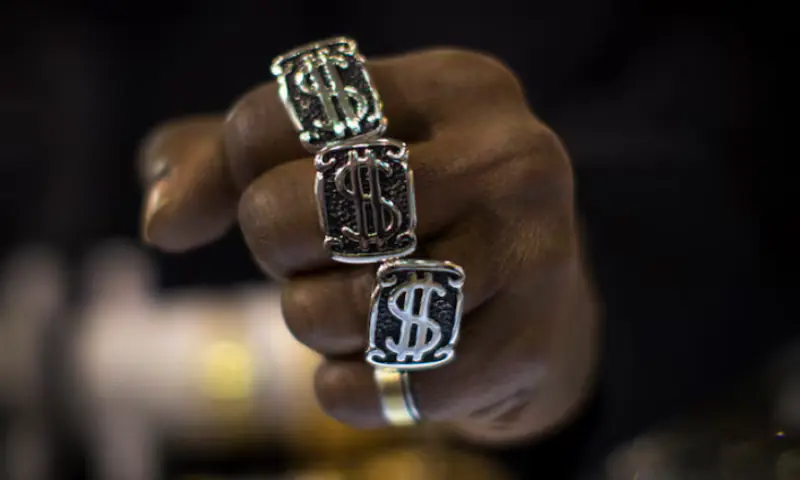 A man wears dollar sign rings in a jewellery shop in New York City. -- Reuters