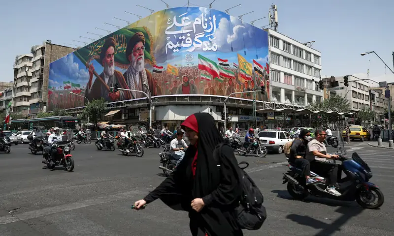 People ride past a billboard depicting the late leaders, Ayatollah Ruhollah Khomeini, and Ayatollah Ali Khamenei, on a street in Tehran, Iran. -- Reuters