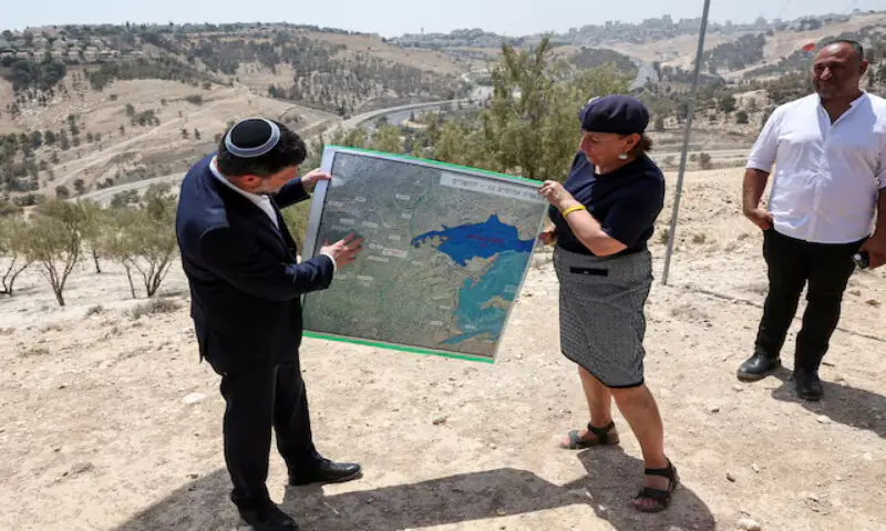 Israeli Finance Minister Bezalel Smotrich and a woman hold a map that shows the E1 settlement scheme, that would split East Jerusalem from the occupied West Bank, near the illegal Israeli settlement of Maale Adumim, in the Israeli-occupied West Bank. -- Reuters file Israeli Finance Minister Bezalel Smotrich and a woman hold a map that shows the E1 settlement scheme, that would split East Jerusalem from the occupied West Bank, near the illegal Israeli settlement of Maale Adumim, in the Israeli-occupied West Bank. -- Reuters file