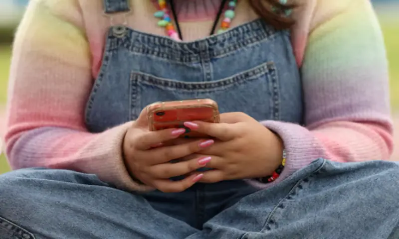 A girl uses her mobile phone in Sydney, Australia. -- Reuters