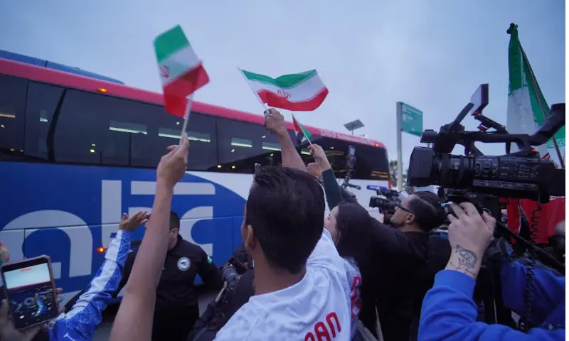 Iran fans look on as the bus arrives. -- Reuters