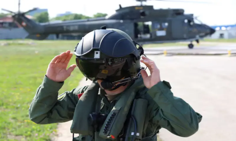 A Swiss pilot member of the NATO-led Kosovo Force (KFOR) adjusts his flight helmet at NATO's headquarters in Pristina, Kosovo. -- Reuters
