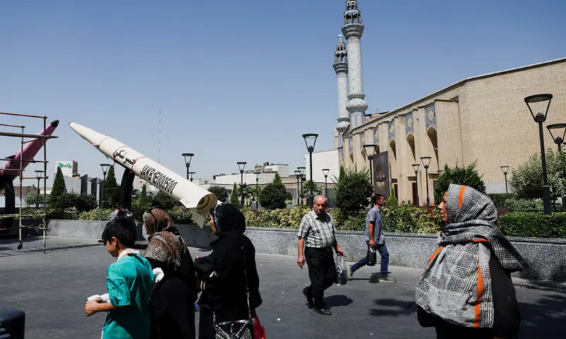 People walk next to a symbolic mock-up of an Iranian missile, on a street in Tehran, Iran. -- Reuters