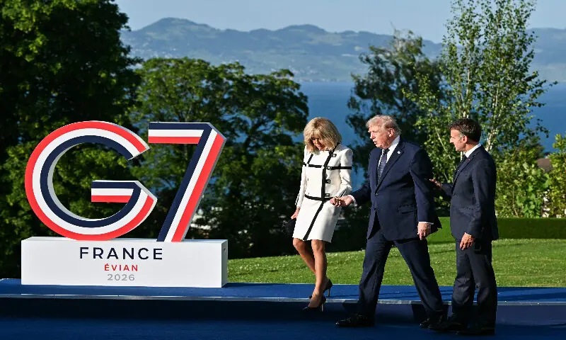 US President Donald Trump (centre) leaves after posing with France's President Emmanuel Macron (right) and his wife Brigitte Macron during the official greeting as part of the G7 summit, in Evian, eastern France, on June 15, 2026. AFP