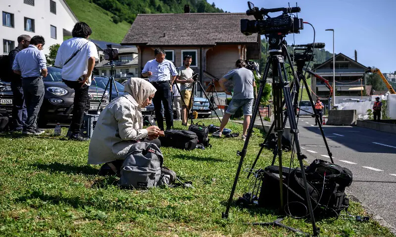 Journalists set up near an access to the Burgenstock luxury hotel complex above Lake Lucerne, where talks following up on a deal to end the Middle East conflict were scheduled to begin on June 19, 2026. AFP