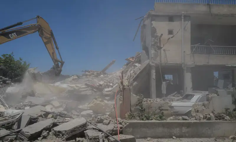 A machine works at the site of an Israeli air strike on a house as rescuers try to recover bodies from under the rubble in Barish in Tyre district, Lebanon. -- Reuters