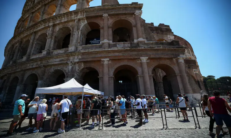 Tourists queue under the sun outside the Colosseum during hot weather in Rome, Italy. -- Reuters