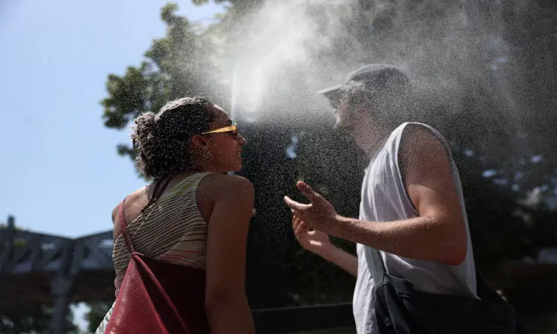 Two persons cool off at a water mister on a street in Paris as temperatures rise during a heatwave affecting a large part of France, on June 22, 2026. Reuters Two persons cool off at a water mister on a street in Paris as temperatures rise during a heatwave affecting a large part of France, on June 22, 2026. Reuters