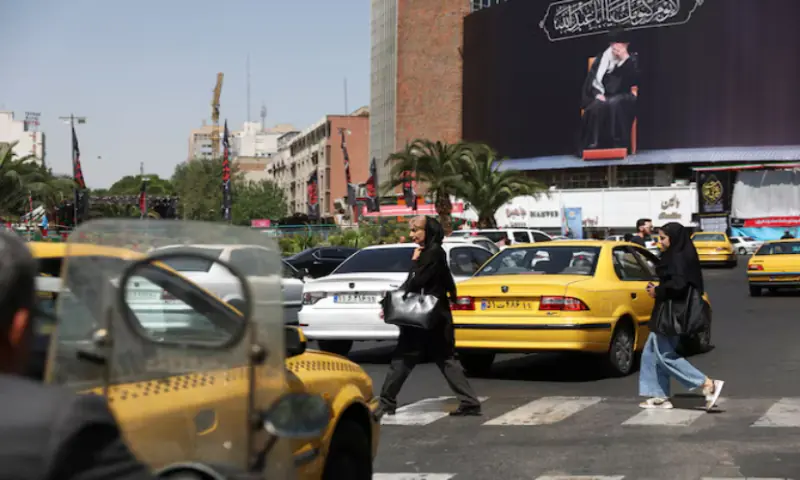 People walk past a billboard with a picture of the Iran's late Supreme Leader Ayatollah Ali Khamenei, in Tehran, Iran. -- Reuters