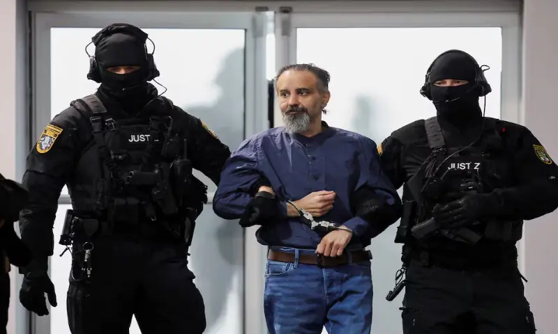 Suspect Taleb al-Abdulmohsen, a doctor from Saudi Arabia who faces charges of murder, attempted murder and dangerous interference with road traffic, is escorted by security officers as he attends his trial for the Magdeburg Christmas market attack, at a regional court in Magdeburg, Germany, on June 26, 2026. Reuters