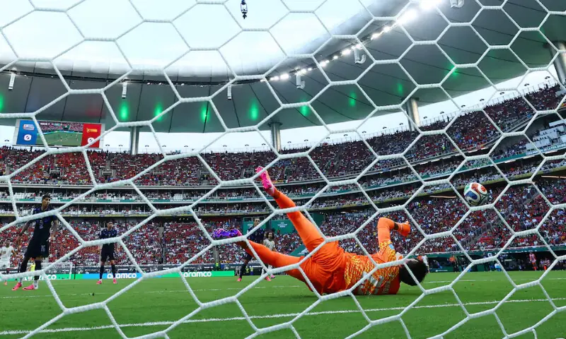 Spain's Alex Baena scores their first goal past Uruguay's Fernando Muslera. -- Reuters