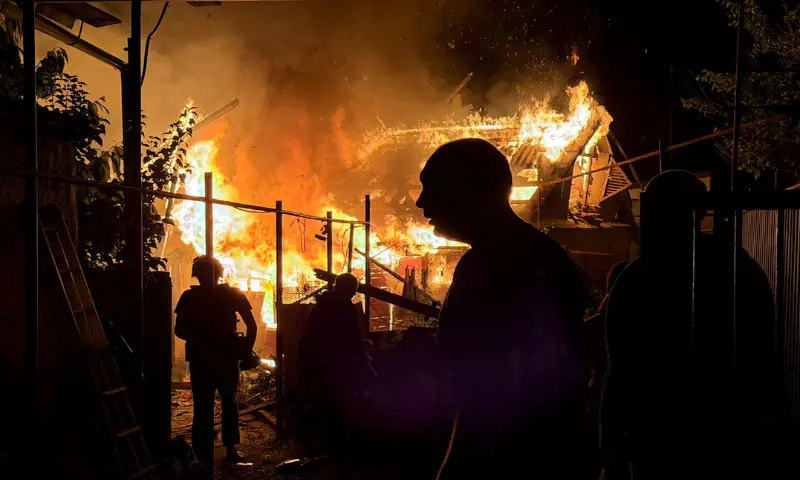 Residents look at a private house that burns after an overnight Russian drone strike, amid Russia's attack on Ukraine, in Zaporizhzhia, Ukraine. -- Reuters