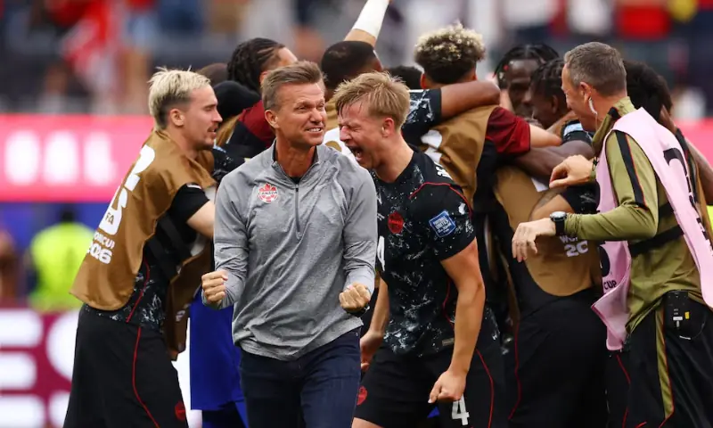 Canada's Stephen Eustaquio celebrates with teammates and coach Jesse Marsch. -- Reuters