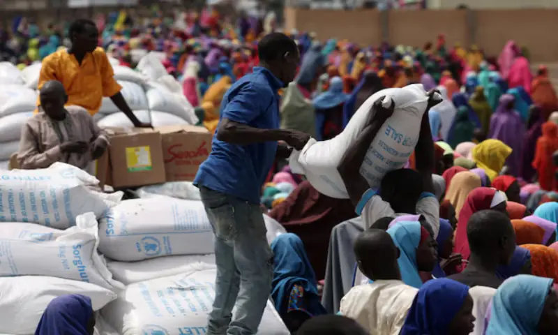 Camp workers offload sorghum at an open field as beneficiaries from different Internally Displaced Persons camps wait to receive support following the exit of USAID, at a World Food Programme distribution centre in Dikwa, Borno State, Nigeria. -- Reuters