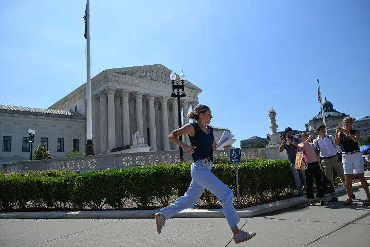 A reporter runs outside the US Supreme Court as the court rejected President Donald Trump's historic bid to restrict birthright citizenship in Washington, DC, on June 30, 2026. AFP