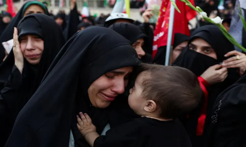 A woman mourns while carrying a child as people gather to pay their respects to late Supreme Leader Ayatollah Ali Khamenei at the Imam Khomeini Grand Mosalla, in Tehran, Iran. -- Reuters