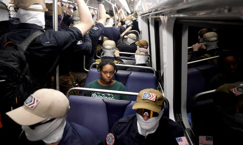 A commuter sits as members of the group Patriot Front ride the metro on the 250th anniversary of US independence on the Fourth of July in Washington, DC. -- Reuters