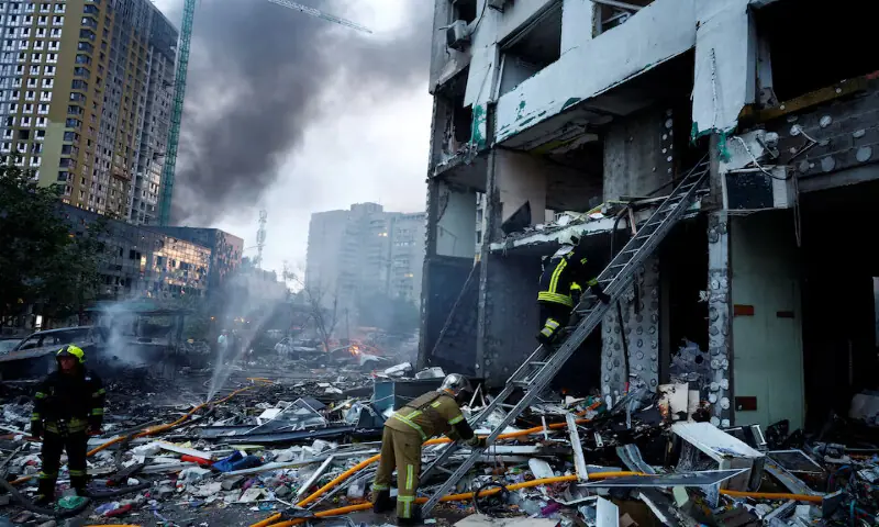A rescuer climbs up a ladder at the site of an apartment building which was heavily damaged during Russian missile and drone strikes in Kyiv, Ukraine, on Monday. -- Reuters
