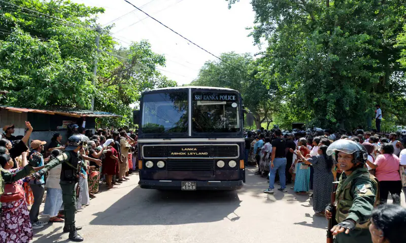 Members of security forces make way for a bus carrying prisoners to be transferred to another prison following clashes between two groups of inmates at Negombo Prison in the coastal town of Negombo, Sri Lanka, on Monday. -- Reuters