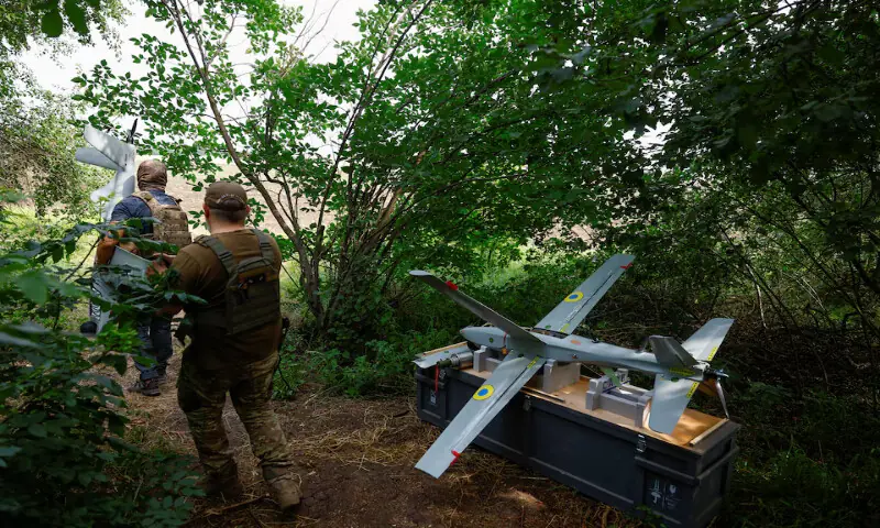 Service members of the Ukrainian Armed Forces carry a Shark reconnaissance drone to a launch point in southern Ukraine. -- Reuters
