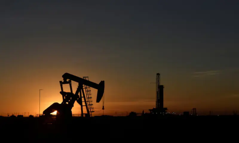 A pump jack operates in front of a drilling rig at sunset in an oil field in Midland, Texas. -- Reuters file