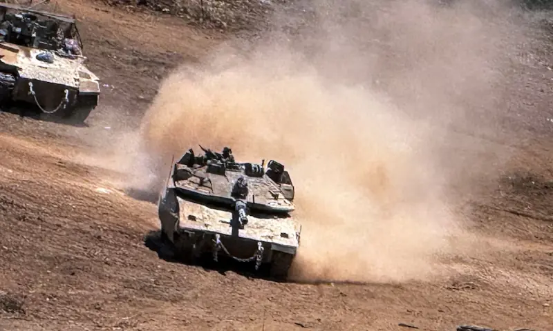 An Israeli tank and an APC maneuver on the Israeli side of the Israel-Lebanon border, after crossing the border into Israel. -- Reuters file
