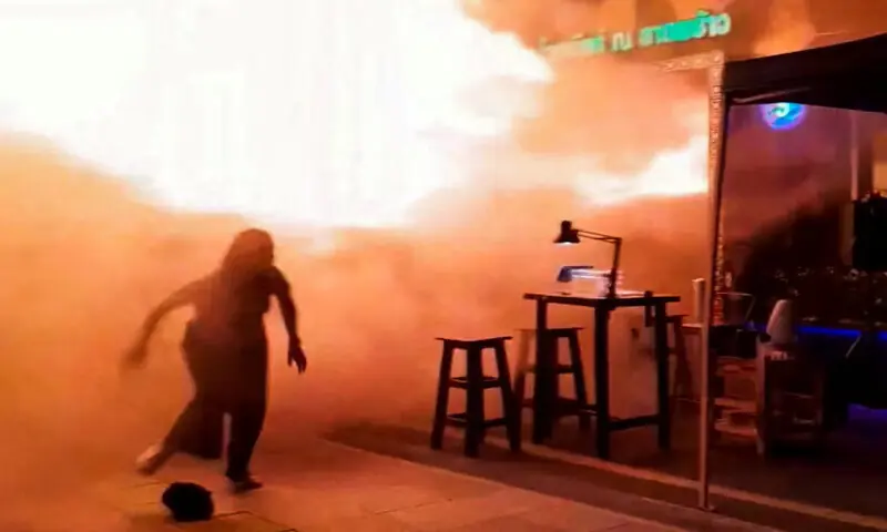 People run as flames rise at a pub in Bangkok, Thailand, in this screengrab taken from a social media video. -- Reuters