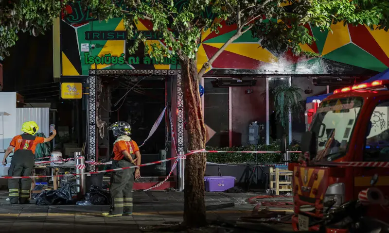 Members of emergency services work outside a pub where a deadly fire broke out in Bangkok, Thailand, on Monday. -- Reuters