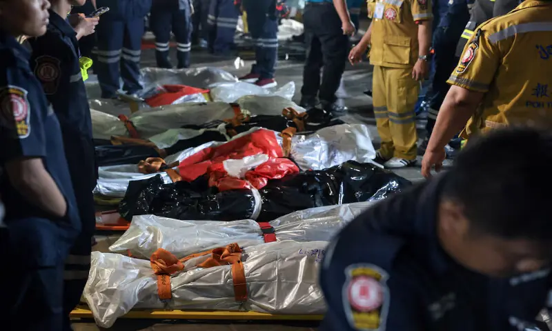 Members of emergency personnel work next to covered bodies at the site of a deadly fire at a pub in Bangkok, Thailand. -- Reuters