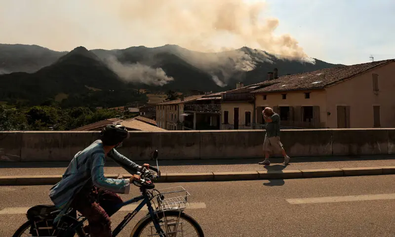 People look at a wildfire which burns mountain vegetation for several days in Die in the Drome department during a heatwave affecting a large part of the country, France. -- Reuters