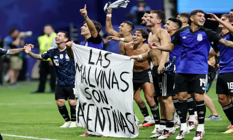Argentina's Lisandro Martinez and Giovani Lo Celso celebrate with a banner after the match as Argentina qualify for the final of the World Cup. -- Reuters