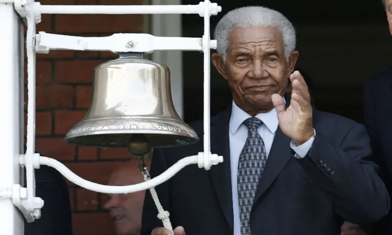 West Indian cricket legend Sir Garfield Sobers waves as he rings the five minute bell before the start of the second session in memory of Muhammad Ali on the second day of the third Test cricket match between England and Sri Lanka at Lord's cricket ground in London on June 10, 2016. AFP