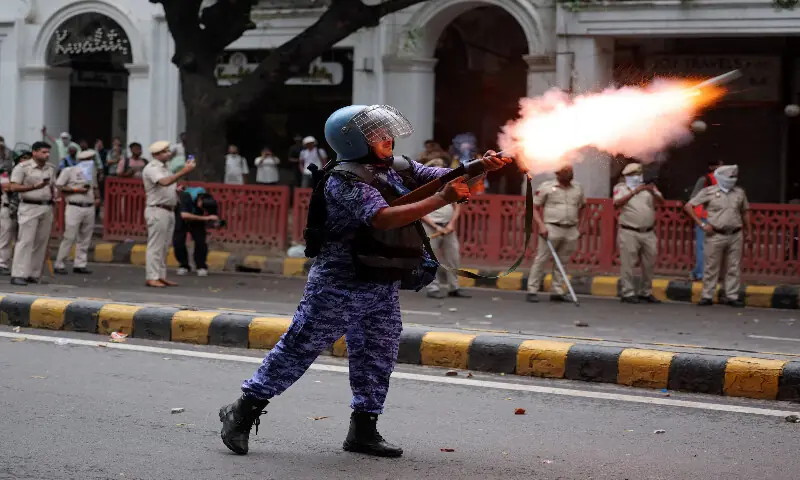 A member of the Rapid Action Force fires a tear gas shell towards protesters in New Delhi. -- Reuters A member of the Rapid Action Force fires a tear gas shell towards protesters in New Delhi. -- Reuters