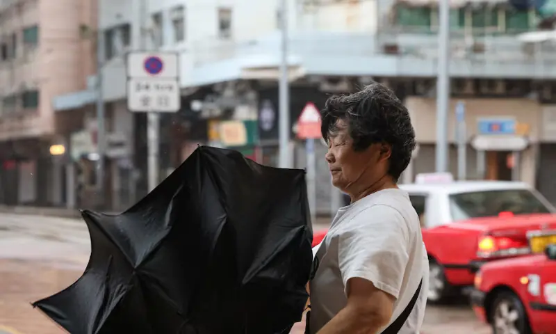 A pedestrian holds an inverted umbrella against strong winds during heavy rain from Typhoon Noul in Hong Kong, China. -- Reuters A pedestrian holds an inverted umbrella against strong winds during heavy rain from Typhoon Noul in Hong Kong, China. -- Reuters