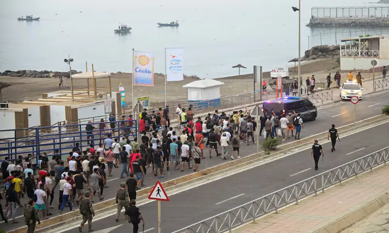 Spanish police officers and soldiers escort a big group of migrants to the border to take them out of Spain in Ceuta, Spain. -- Reuters